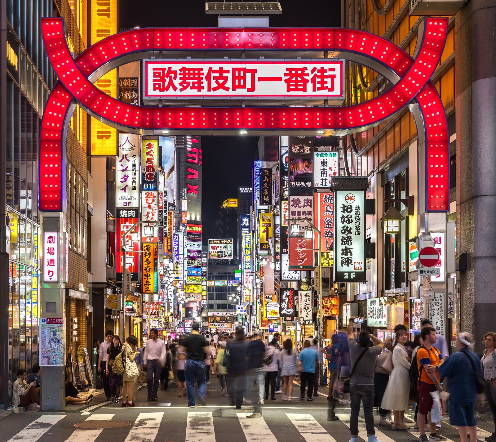 Portal vermelho luminoso e letreiros de neon coloridos na entrada do distrito de entretenimento noturno de Kabukicho em Tóquio Japão - NANI JLPT